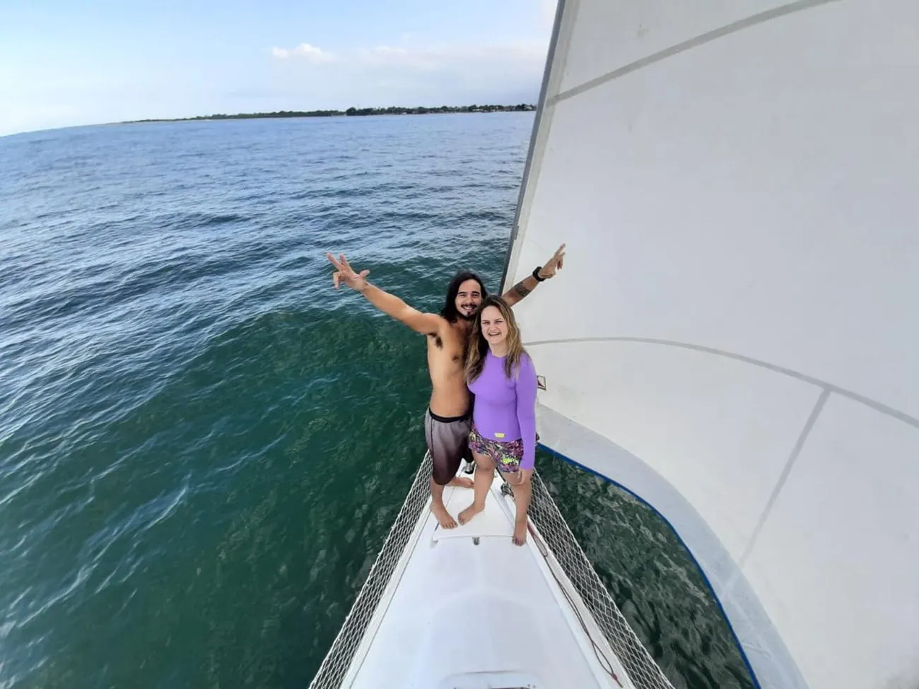 La pareja del Limonada en la proa del velero, con los brazos abiertos
